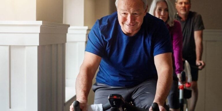 Elderly Man Smiling While Using Exercise Bike At Independent Living Facility