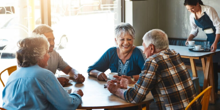 Group of Seniors Having Coffee Together in a Dining Area at an Independent Living Facility